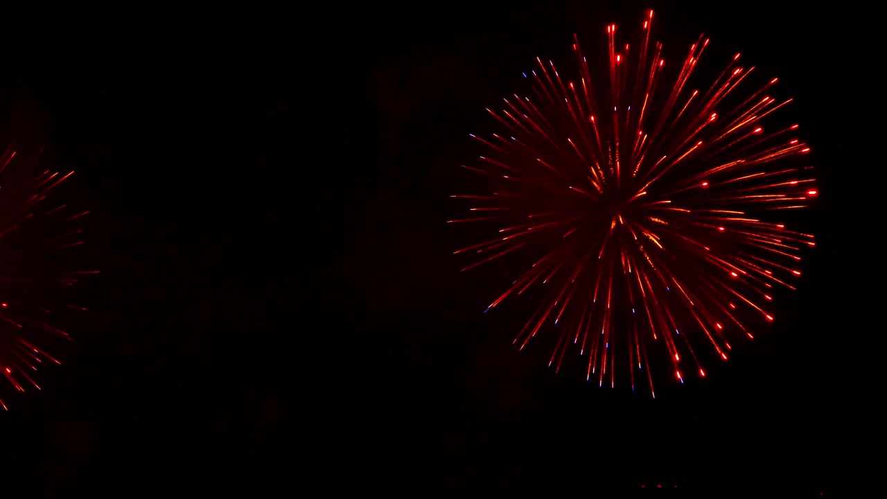 Fuochi d'artificio colorati che esplodono nel cielo notturno, creando un'atmosfera festosa spettacolare con scintille luminose, scie incandescenti e giochi di luce drammatici