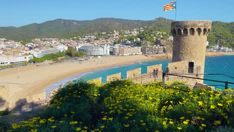 Bahía-De-Tossa-De-Mar-Vista-Desde-El-Castillo-Hasta-La-Playa-Con-Arena-Gruesa-Y-Agua-De-Mar-Azul-Turquesa-Antiguo-Pueblo-Pesquero-Medieval-Amurallado-Mar-Mediterráneo