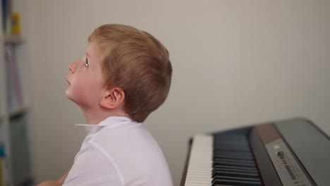 El-Niño-Soñador-Se-Sienta-Frente-Al-Piano-Eléctrico-Ignorando-La-Lección.