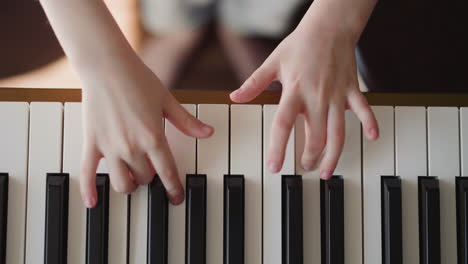 Kid-hands-play-electric-piano-practicing-legato-articulation