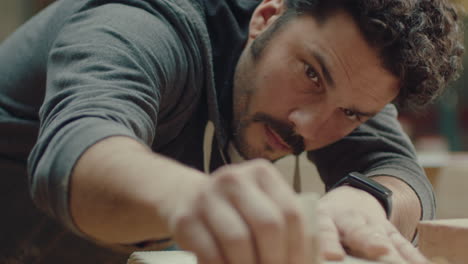 craftsman polishing edges of wooden tray with sandpaper