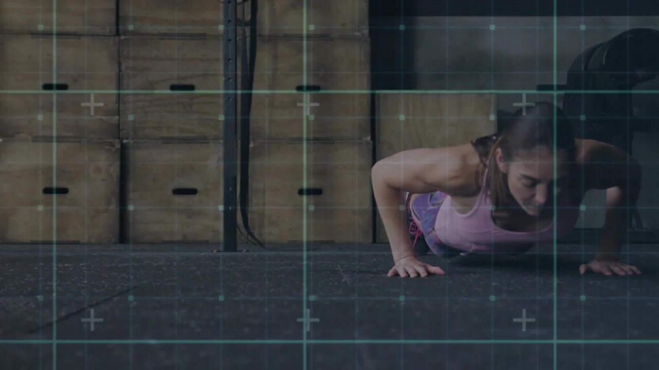 Inizio ripresa con telecamera ad angolo basso, donna che esegue burpees sul pavimento, griglia ciano sovrapposta che guida l'allenamento