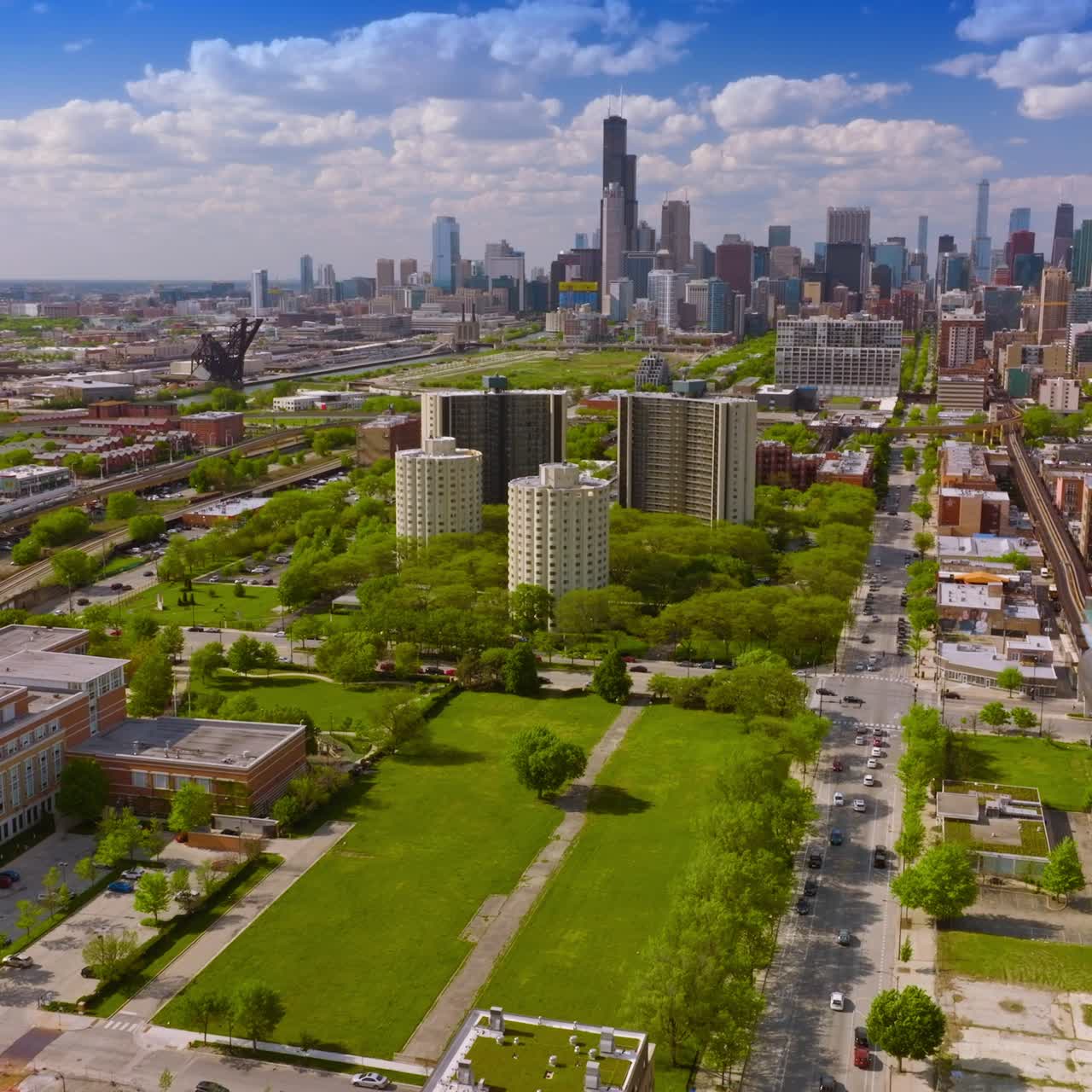 Estrada e ferrovias paralelas do metrô atravessando a cidade. Cenário ensolarado do distrito verde de Chicago durante o dia. Vista de cima