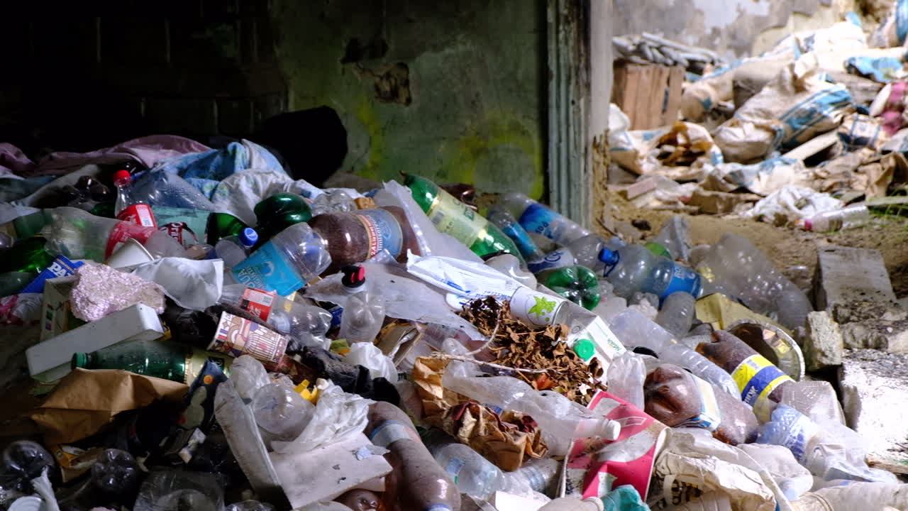 A pile of plastic bottles and garbage in an abandoned buiding
