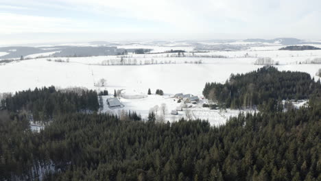 Toma-Aérea-Del-Campamento-De-La-República-Checa-En-Un-Hermoso-Paisaje-Natural-Invernal,-Alojamiento-En-Cabañas-De-Madera