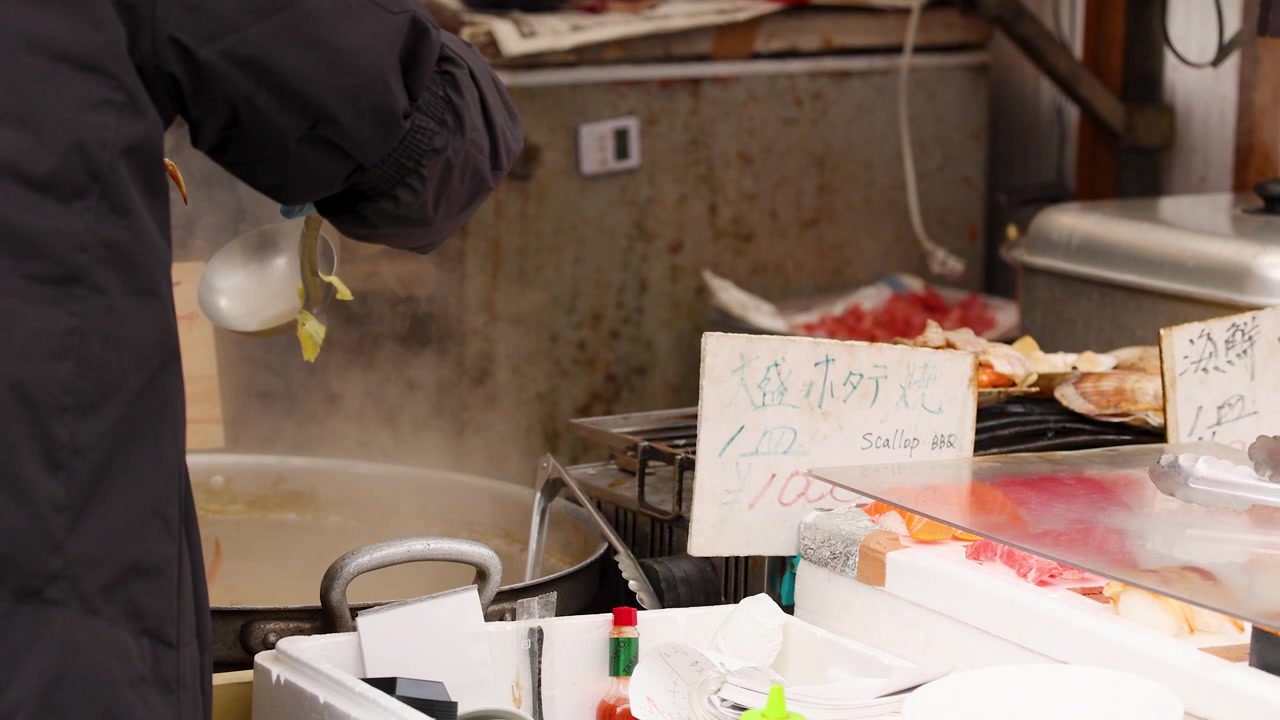 Venditore ambulante di street food che prepara frutti di mare in un mercato affollato