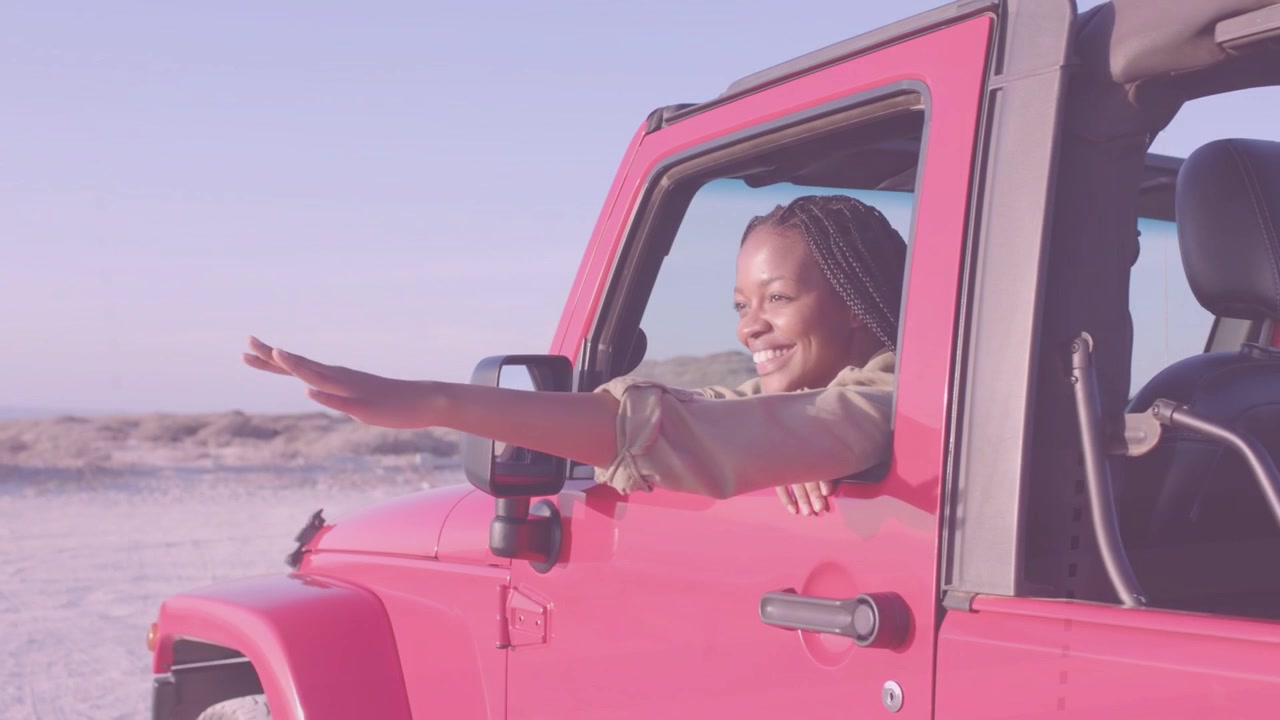 Donna che si appoggia al finestrino di una Jeep rossa, sentendo la brezza, allungando la mano, un bagliore animato che traccia la mano, auto