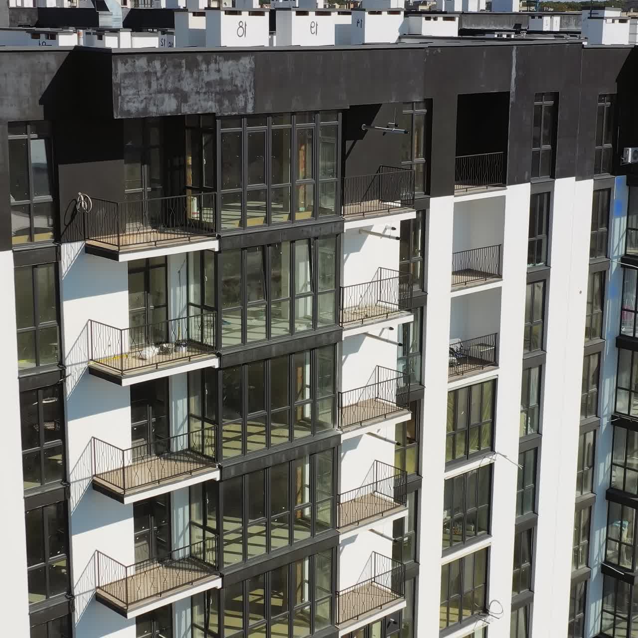 New architecture in the city. High-raise apartment buildings near the road. Modern design of multistorey building. Drone flight