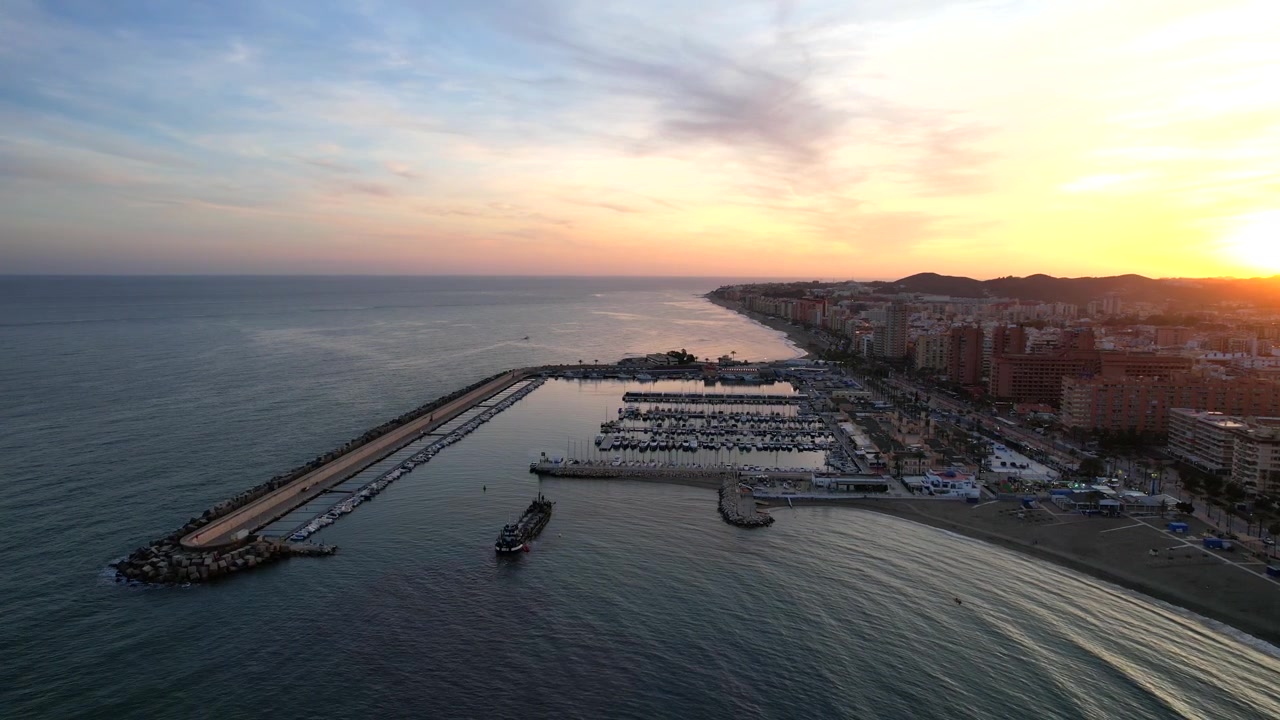 Ripresa aerea in discesa sulle colline di Fuengirola, porto spagnolo, al tramonto