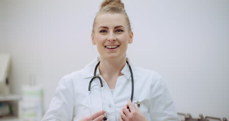 positive doctor puts on stethoscope and smile