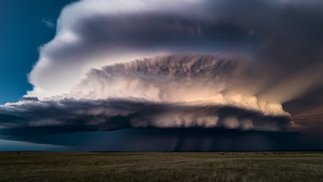 dramatic supercell thunderstorm with lightning over a flat landscape