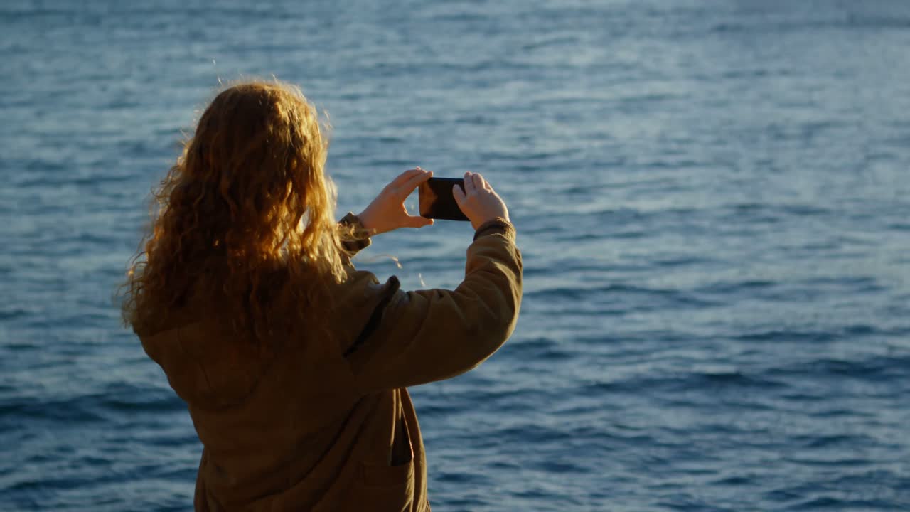 mujer haciendo clic en fotos con teléfono móvil en el muelle 4k