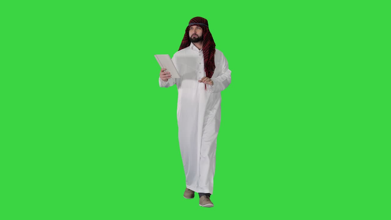 Sceicco che usa un tablet digitale e cammina su uno schermo verde, Chroma Key