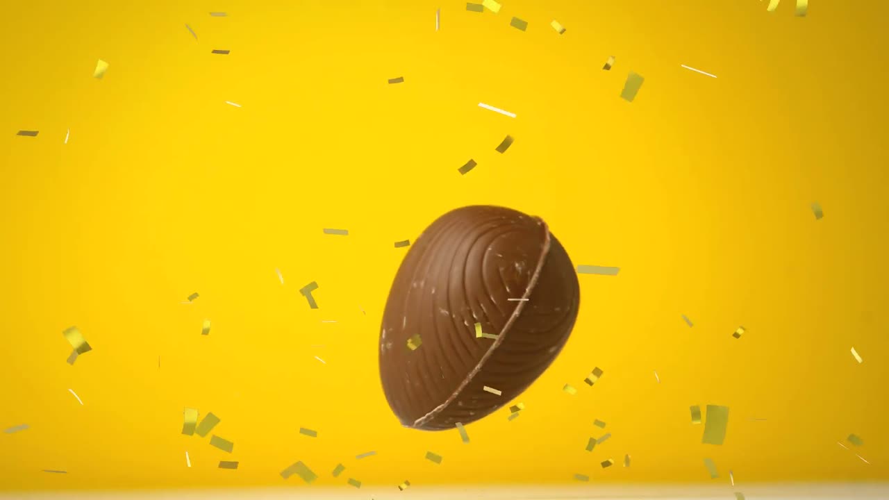Animazione di uovo di Pasqua di cioccolato che cade e coriandoli dorati che volano su sfondo giallo