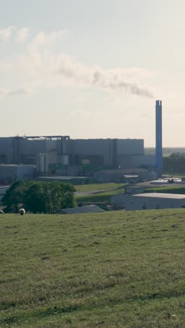 industrial plant with emitting chimneys in a rural landscape