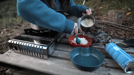 Sacando-Arroz-De-Una-Olla-En-La-Naturaleza,-Al-Aire-Libre,-Acampando