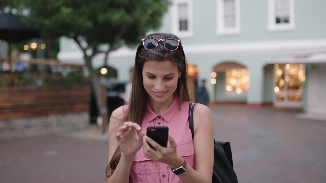 retrato en cámara lenta de una mujer joven y hermosa sonriendo feliz enviando mensajes de texto usando una aplicación de redes sociales para teléfonos inteligentes
