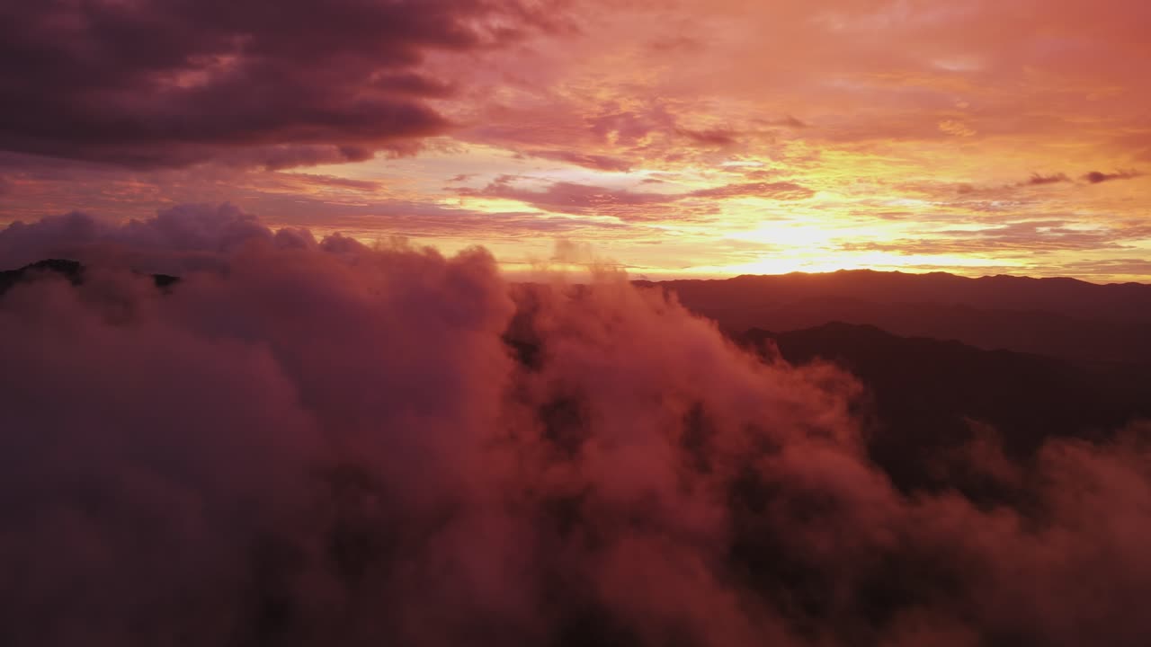 drone 4k sobre nubes esponjosas con tono rojo y puesta de sol brillante, 4k