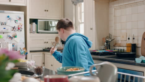 happy-teenage-boy-with-down-syndrome-dancing-in-kitchen-having-fun-celebrating-funny-dance-enjoying-weekend-at-home