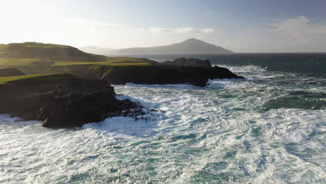 Cinematic-drone-rotating-shot-of-the-ocean-waves-against-coastline-at-the-White-Cliffs-of-Ashleam,-Ireland