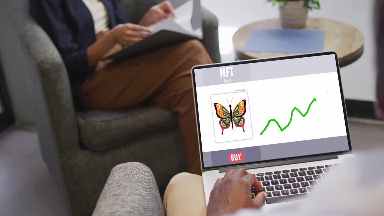 video de una mujer biracial trabajando en una computadora portátil con nft en la pantalla