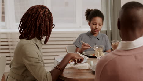 daughter sharing story with parents at dinner