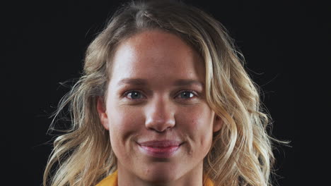 close up head and shoulders studio shot of woman laughing at camera in slow motion