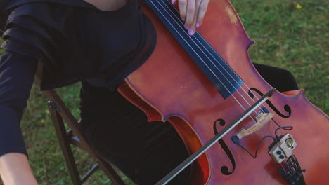 woman playing cello outdoors