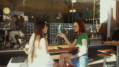 two women talking at an outdoor cafe