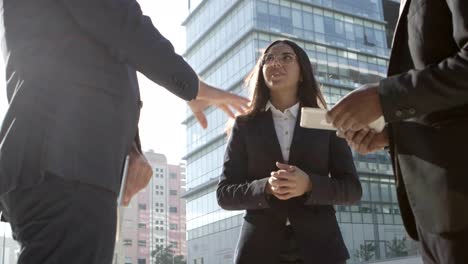 Coworkers-with-digital-tablets-talking-on-street