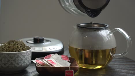 Filling-up-tea-pot-of-Cerasee-kerala-bitter-melon-plant-with-kerala-hanging-from-vines-used-to-make-herbal-healthy-tea-good-for-weight-loss