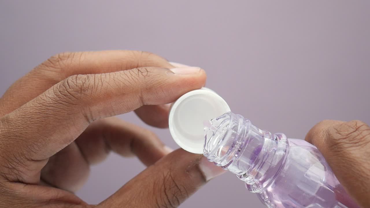 vertiendo líquido púrpura de una botella