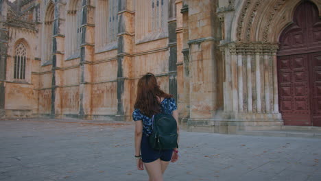 monastery of batalha girl walks on the exterior of the monastery gimbal shot medium shot