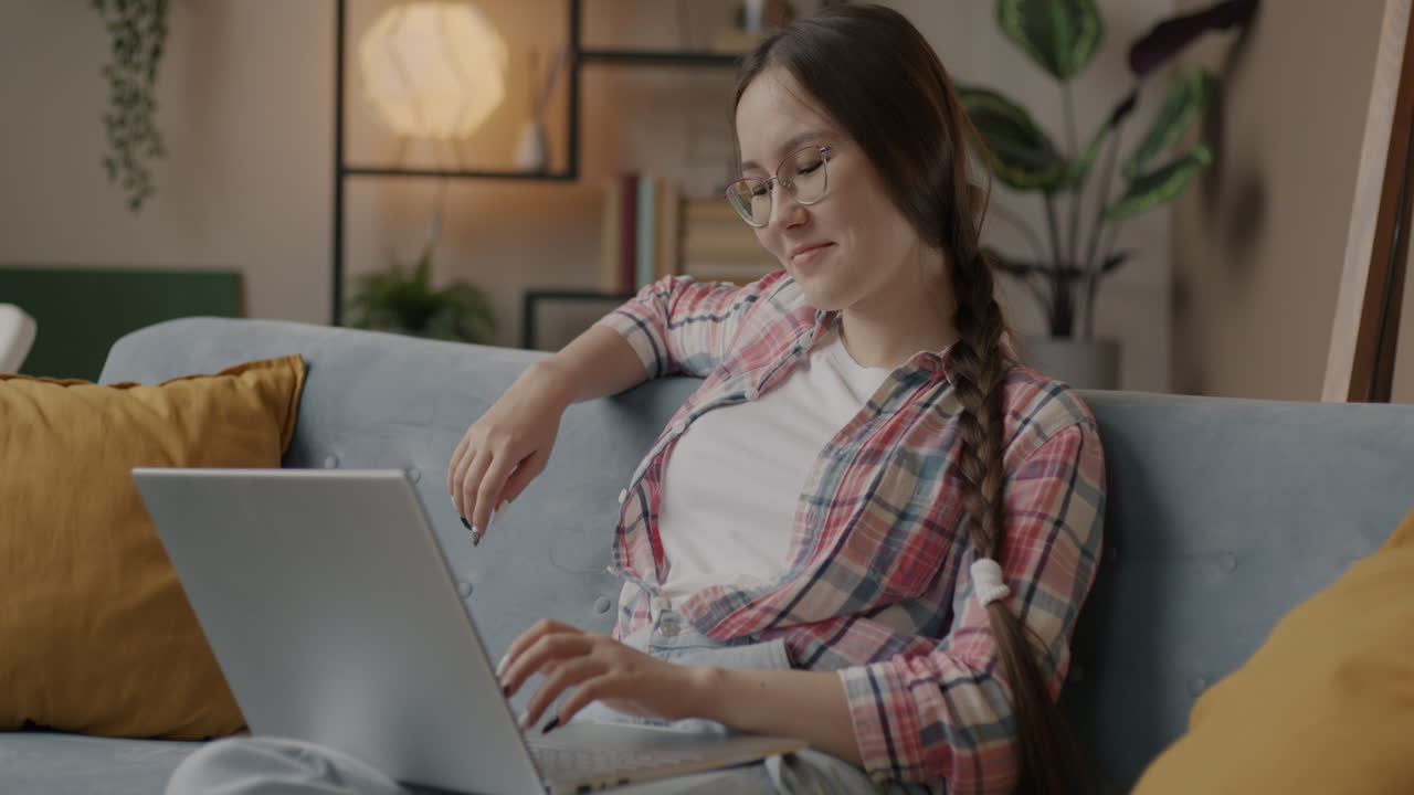 mujer joven trabajando en una computadora portátil en casa