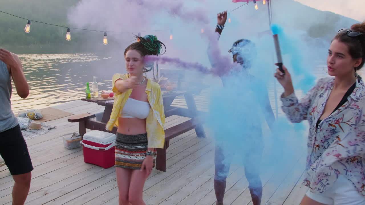호수 파티에서 연기 폭탄과 함께 부두에서 춤을 추는 소녀들