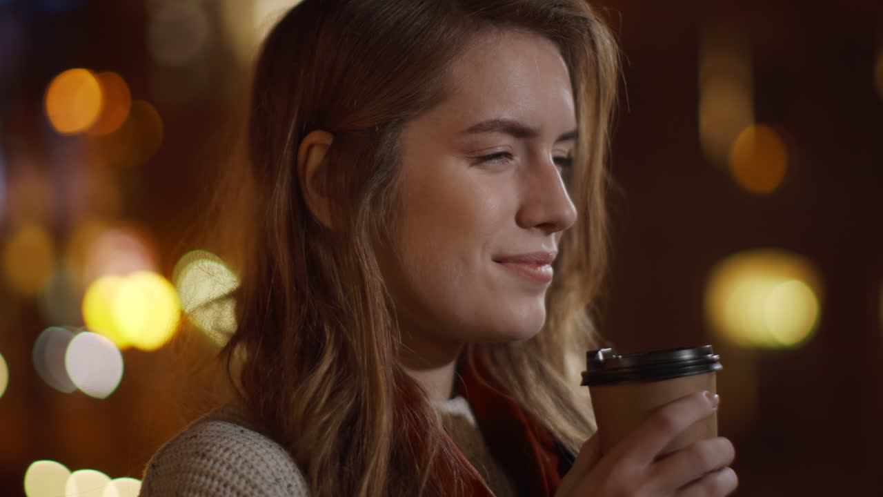 Chica tranquila tomando café en la calle. Mujer relajada bebiendo una bebida caliente para llevar.
