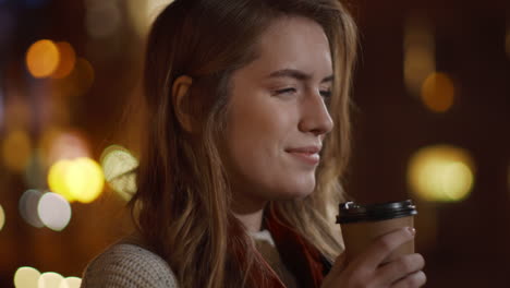 calm girl having coffee on street. relaxed woman drinking take away hot drink