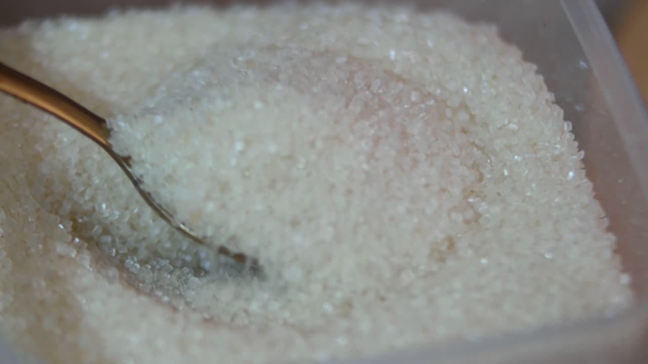 Primer plano de una cucharada de azúcar granulado