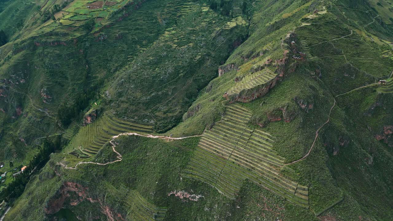 vista aérea muestra la rica historia y la belleza natural de pisac, con terrazas y caminos que conducen a pueblos encantadores