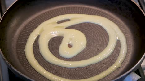 overhead close up shot of a traditional cast iron skillet being greased for use