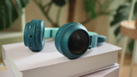 turquoise headphones on a stack of books