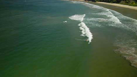 Vista-Aérea-De-Un-Surfista-Remando-Y-Pierde-Una-Ola-En-La-Bahía-De-Las-Cuevas,-Trinidad