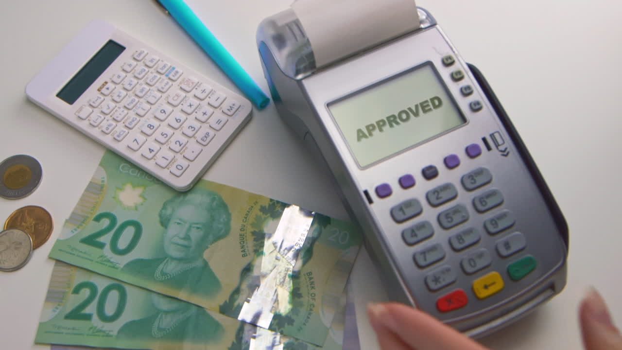 A caucasian woman's hand swipes a card into a debit machine