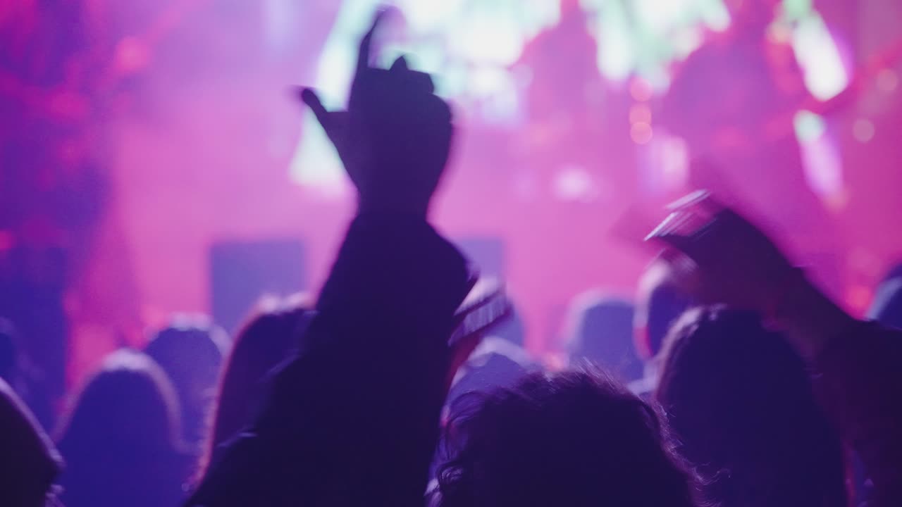 Sagome di persone che agitano le mani a un vivace concerto dal vivo