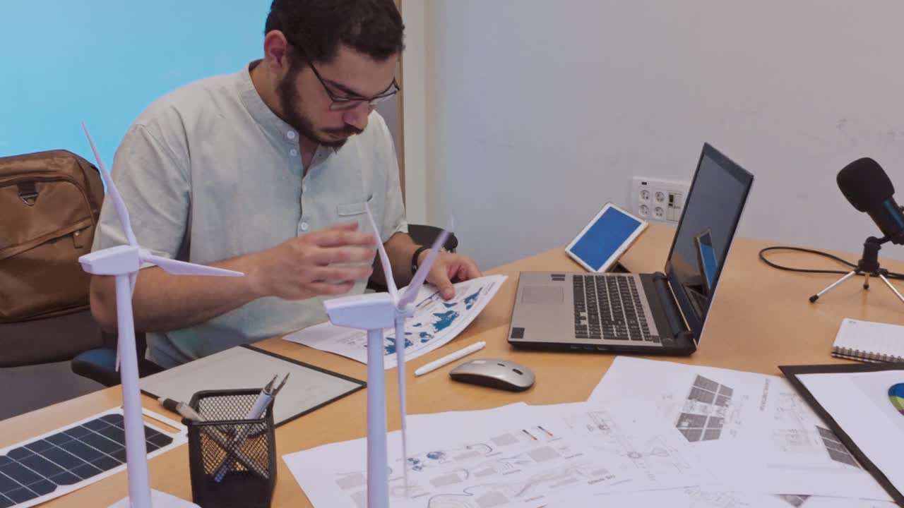 Man working on sustainable energy project with models and technology