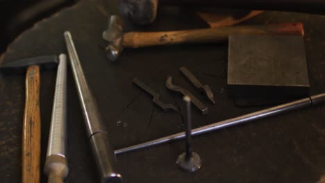 close up of diverse jeweller tools lying on desk in workshop