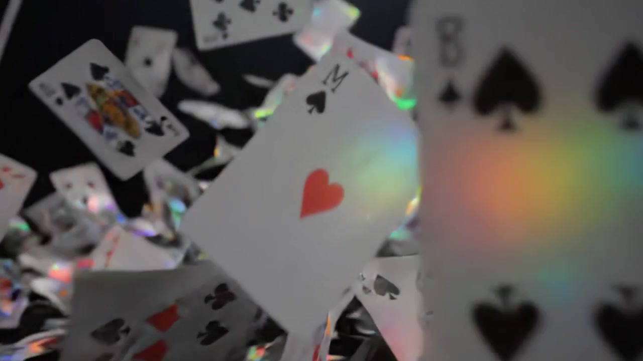 A Dramatic Sequence of Playing Cards Falling from the Air, Creating a Colorful Explosion Before Settling into a Vibrant Pile on the Ground