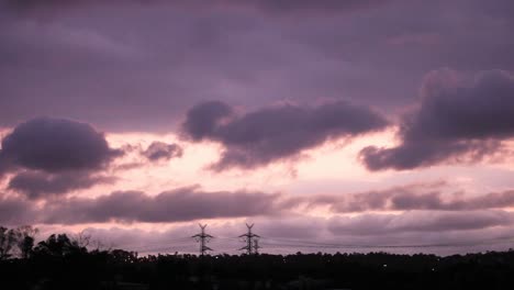 ominous storm clouds rolling past urban electricity pylon distribution lines