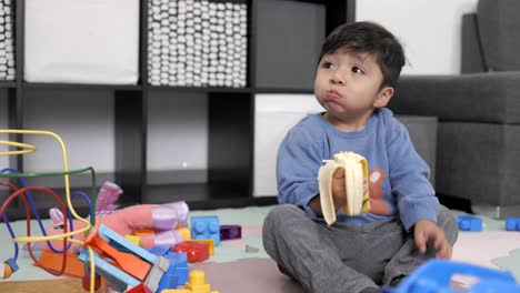 Zwei-Jahre-Alter-Mexikanischer-Junge,-Der-Bananen-Isst-Und-Fernsieht