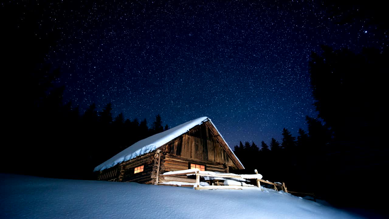 time-lapse. hermosa casa de madera en el bosque de invierno bajo las estrellas
